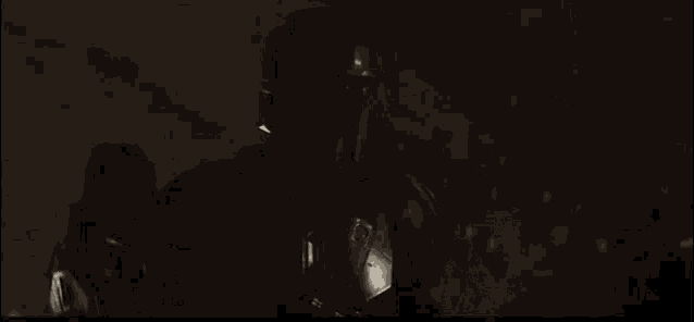 a man in a helmet is carrying a baby in a dark room .