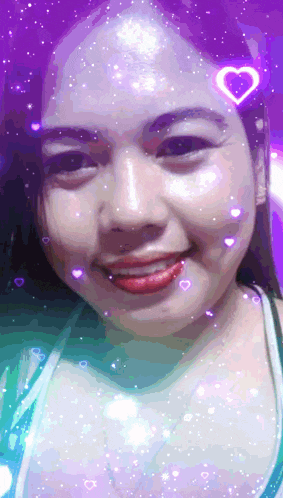 a woman with a heart on her forehead smiles for the camera