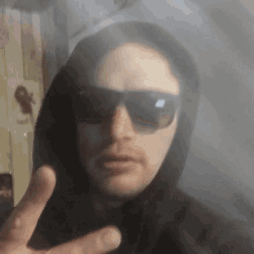 a man wearing sunglasses and a hooded jacket
