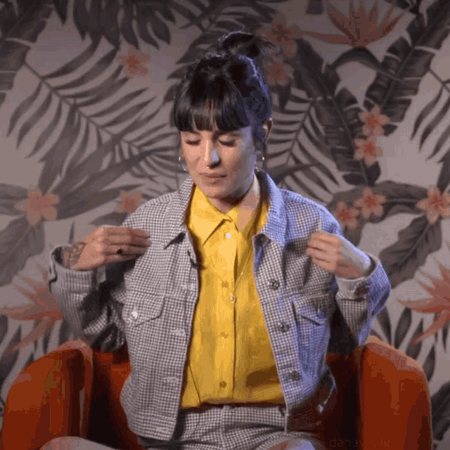 a woman wearing a plaid jacket and a yellow shirt
