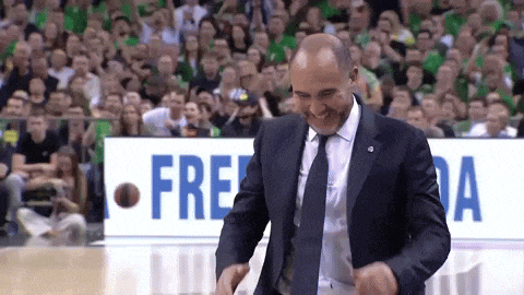 a man in a suit and tie is dancing on a basketball court in front of a sign that says freeda