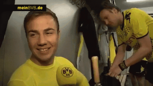 a man in a yellow shirt with bvb on it is smiling