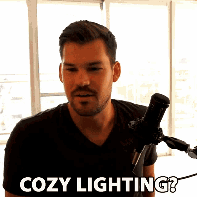 a man standing in front of a microphone with the words cozy lighting above him