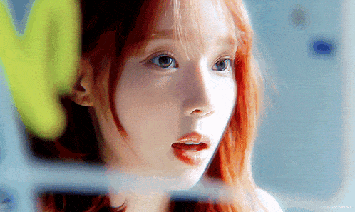 a close up of a woman 's face with a yellow letter m in the background