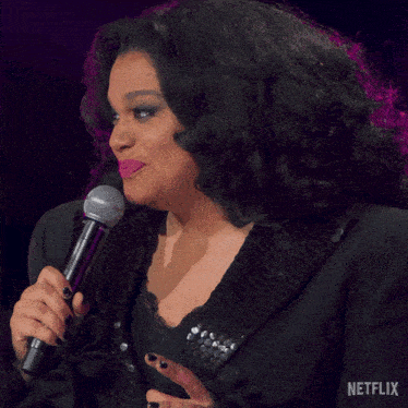 a woman is singing into a microphone with a netflix logo in the background
