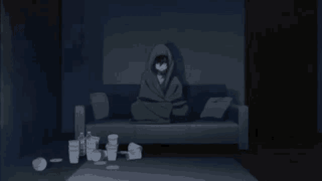 a person is laying on a couch in a dark room surrounded by trash .