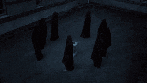 a group of people are standing in a circle around a small white object