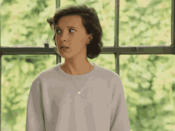 a woman is standing in front of a window with her eyes closed