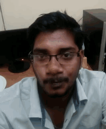 a man wearing glasses and a white shirt is looking at the camera