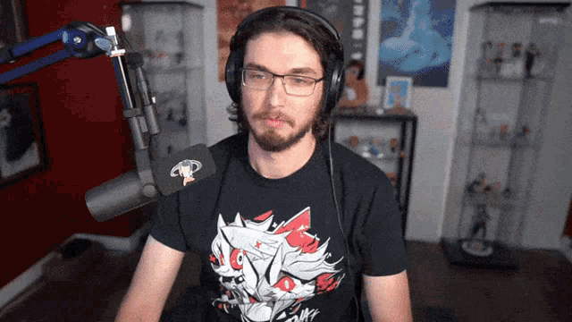 a man wearing headphones and a black t-shirt with a cat on it