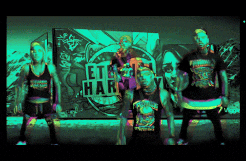 a group of people are standing in front of a wall that says " let 's party "