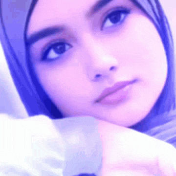 a close up of a woman 's face wearing a hijab .