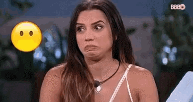 a woman is making a funny face in front of a smiley face .
