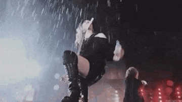 a woman is kneeling on a stage in the rain .