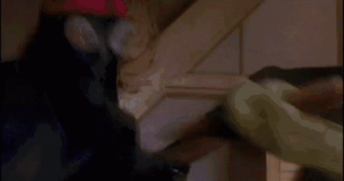 a person is laying on a couch in a dark room with a staircase in the background .