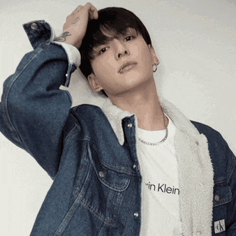 a man wearing a denim jacket and a calvin klein shirt