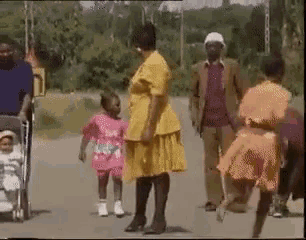 a woman in a yellow dress is standing next to a little girl in a pink dress .