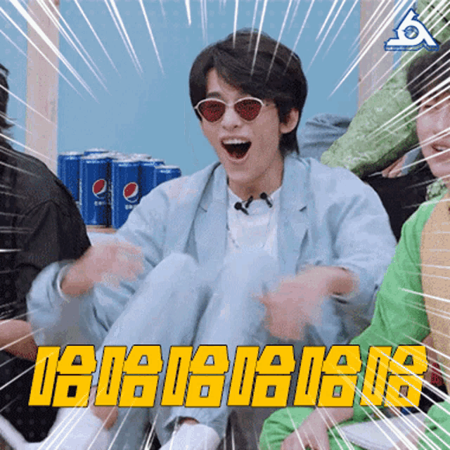 a man wearing sunglasses and a blue jacket is sitting in front of a pepsi can