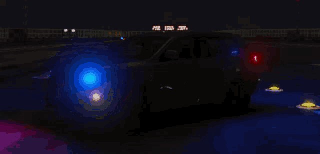 a police car is driving down a street at night with a red light on