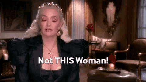 a woman is standing in a living room with her eyes closed and says not this woman .