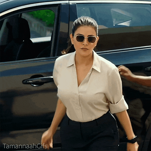 a woman wearing sunglasses is getting out of a car and tamannah gifs is below her