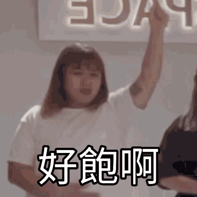 a woman in a white shirt is holding her arm up in front of a sign that says ' sda '
