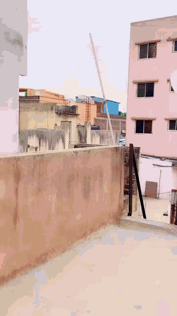 a woman is standing on a balcony with a vivo satellite dish in the background .