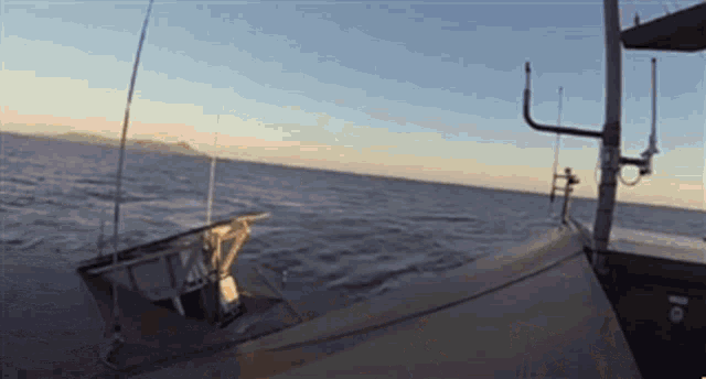 a boat is floating on top of a body of water with mountains in the background