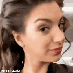a close up of a woman 's face with her hair in a braid .