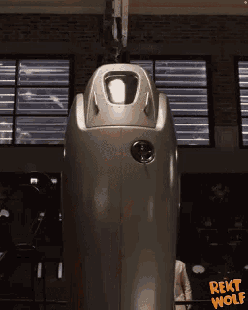 a man is standing in front of a large metal object that says rekt wolf on the bottom