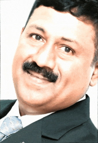 a man with a mustache wearing a suit and tie smiles