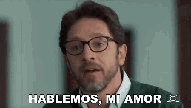 a man with glasses says " hablemos mi amor "