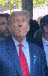 a man in a suit and red tie stands in a crowd
