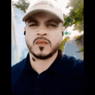 a man with a beard wearing a hat and ear buds .