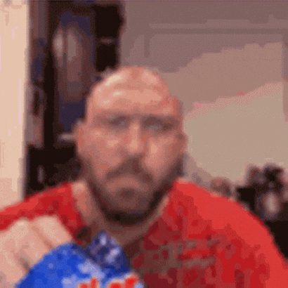 a bald man with a beard is holding a bag of chips in his hand .