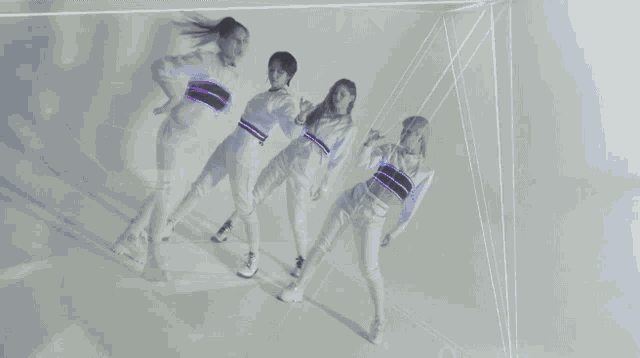 a group of women are dancing in a room with a triangle in the background