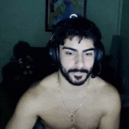 a shirtless man with a beard wearing headphones and a cross necklace