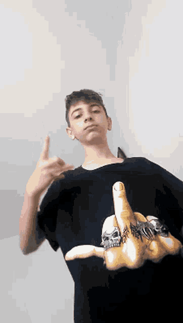 a boy wearing a black shirt with a picture of a hand giving a middle finger