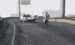 a man in a trench coat is running down a highway .