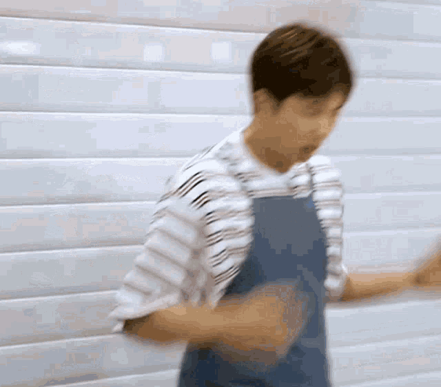 a man wearing an apron and a striped shirt is dancing .