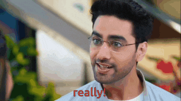 a man with glasses and a beard is smiling and says really