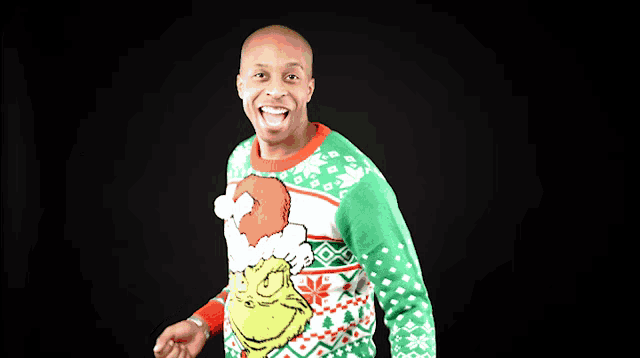 a man wearing an ugly christmas sweater with grinch on the front