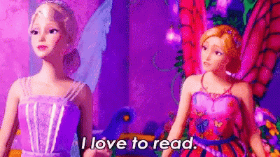 two barbie dolls are standing next to each other in a purple room .