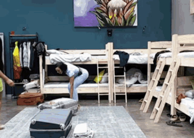 a woman is packing a suitcase in a bunk room