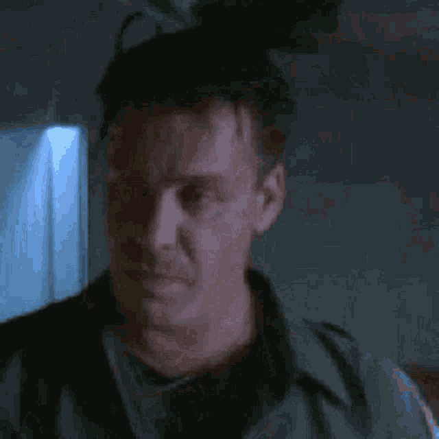 a close up of a man 's face in a dark room with his eyes closed .