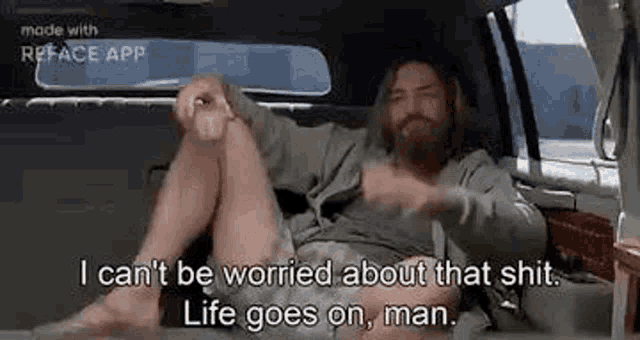 a man is sitting in the back seat of a car .
