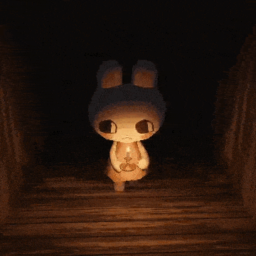 a stuffed bunny is holding a candle in a dark room .
