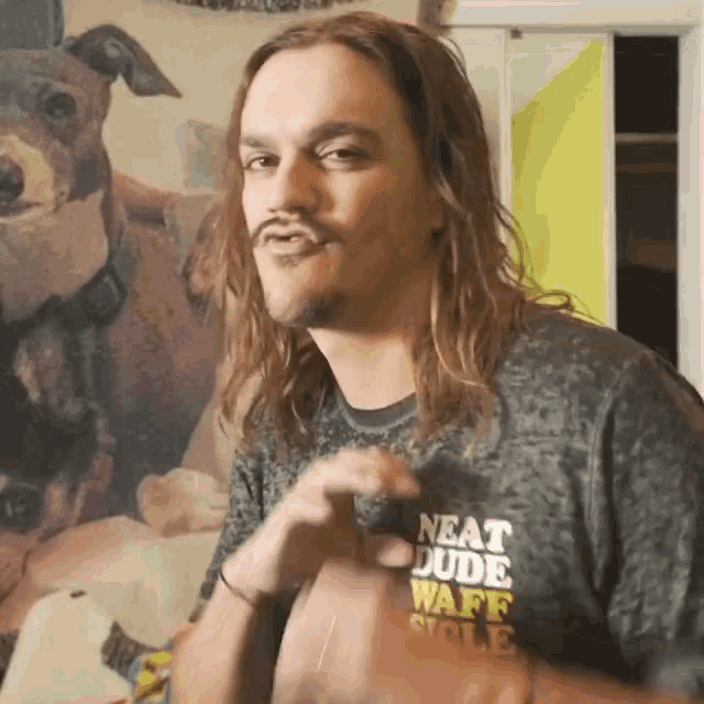 a man with long hair is wearing a shirt that says neat dude ware