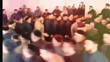 a large group of people are dancing in a circle .