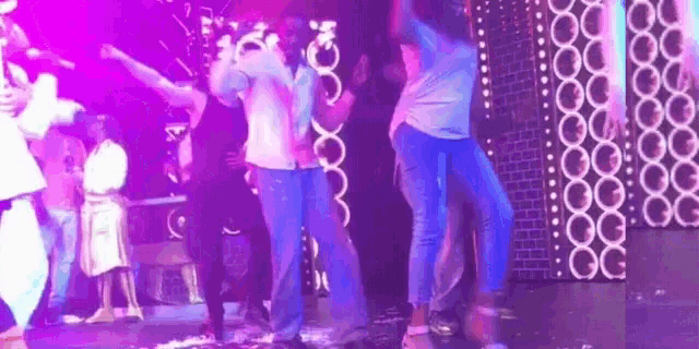 a group of people are dancing in a dark room